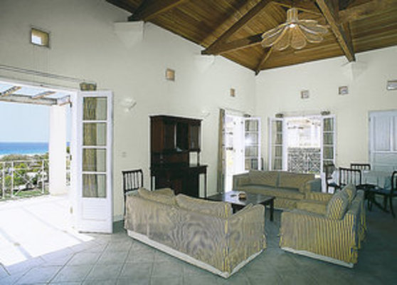 Helles Wohnzimmer mit Holzdach und eleganten Möbeln, das durch große Türen einen Blick auf das Meer bietet. Helles Wohnzimmer mit Holzdach und eleganten Möbeln, das durch große Türen einen Blick auf das Meer bietet.