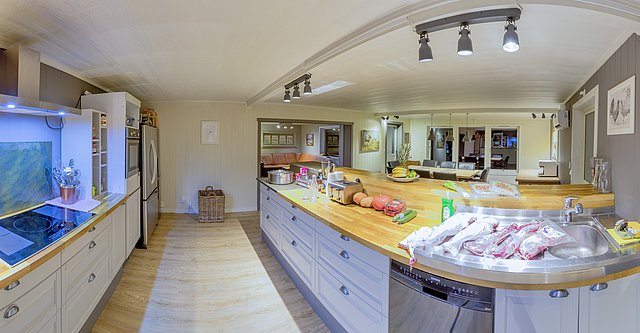 Moderne Küche in Nordland, Norwegen: Helle Holzelemente, großzügige Arbeitsplatten, Einbauleuchten und offene Raumgestaltung. Perfekt für Angelurlauber zum Kochen frischer Fänge. Entspannende Atmosphäre in skandinavischem Design.