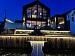 Modernes Haus am Wasser in Südwest-Norwegen, stimmungsvoll beleuchtet bei Nacht. Große Fensterfronten bieten Einblicke ins stilvolle Interieur. Perfekter Ausgangspunkt für Angelurlaube in Norwegen. Entdecke Abenteuer und Komfort in skandinavischer Idylle.