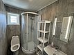 Modernes Badezimmer in Hitra, Norwegen, mit Dusche, WC und beleuchtetem Spiegel. Ideal für komfortable Angelreisen in skandinavischer Atmosphäre. Perfekte Unterkunft für Abenteurer und Erholungssuchende. Hell und funktional gestaltet.