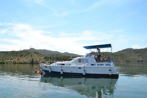 Ein Boot auf ruhigem Wasser in Riba Roja, Spanien, umgeben von grünen Hügeln – ideal für Angelreisen und Naturerlebnisse. Perfekt für entspannte Abenteuer und sorgloses Angeln.