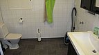Helles, funktionales Badezimmer in Hitra, Norwegen: Weiße Fliesen, modernes Waschbecken, Toilette, Handtuchhalter. Praktisch für Angelreisende, die Komfort und Sauberkeit suchen. Ideal für entspanntes Erholen nach einem erfolgreichen Angeltag.