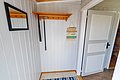 Gemütlicher Eingangsbereich in Hitra, Norwegen, mit herzlichem „Velkommen“-Schild, hellem Holzdekor und Spiegel. Perfekt für Angelurlaub. Barrierefrei gestaltet, lädt zum Entspannen nach einem erfolgreichen Angelausflug ein.