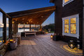 Gemütliche Terrasse in Südwest-Norwegen mit Holzverkleidung und stimmungsvoller Beleuchtung bei Dämmerung. Perfekter Ort für entspannte Angelabende, umgeben von malerischer Fjordlandschaft und ruhiger Atmosphäre. Ideal für Angelurlaub und Naturgenuss.