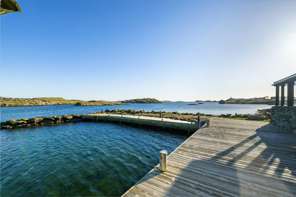 Klares Wasser und hölzerne Stege in Südwest-Norwegen. Perfekt für Angelreisen, umgeben von idyllischen Landschaften. Ideal für Meeresangeln und Entspannung, bietet die Region Abenteuer und Ruhe.
