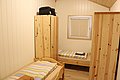 Gemütliches Schlafzimmer in Norwegens Hitra, mit zwei Einzelbetten, Holzschrank und Fenster. Helle, einladende Atmosphäre für Angeltouren. Perfekte Unterkunft für Erholung nach aufregenden Abenteuern in der Umgebung. Ideal für Angelurlaub in Norwegen.