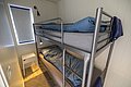 Modern eingerichtetes Schlafzimmer in Hitra, Norwegen, mit Etagenbett und schlichter Dekoration. Ideal für Angelurlauber, die Komfort und Erholung nach einem erlebnisreichen Tag auf See suchen. Helles Design mit praktischem Nachttisch.