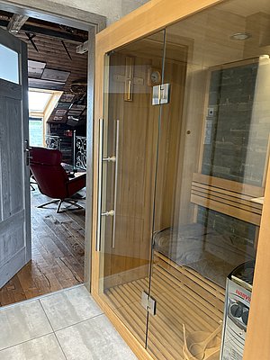 Eine moderne Sauna mit Glasfront in einer gemütlichen Hütte in Nord-Norwegen. Perfekt zum Entspannen nach einem spannenden Angelurlaub. Elegantes Design mit Holzelementen und einladender Atmosphäre.