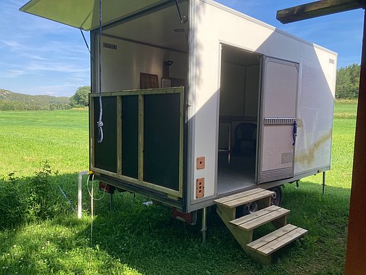 Moderner Wohnwagen in einer grünen Wiese bei Hitra, Norwegen. Perfekt für Angelurlaub, umgeben von Natur und ideal als Rückzugsort nach einem spannenden Angeltag. Barrierefreier Zugang durch kleine Treppe.