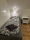 Gemütliches Einzelzimmer in Nord-Norwegen mit hellem Holzinterieur, Bett mit gemusterter Bettdecke und Nachttisch, ideal für erholsame Nächte während Ihres Angelurlaubs. Perfekt für Entspannung nach einem erfolgreichen Angeltag.