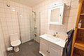 Helles Badezimmer in Nord-Norwegen mit moderner Dusche, WC, weißem Waschbecken und praktischem Spiegelschrank. Ideal für erholsamen Angelurlaub. Barrierefreiheit durch ebenerdigen Zugang, komfortable Ausstattung für größtmögliche Entspannung.