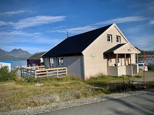 Gemütliches Holzhaus in Nord-Norwegen, umgeben von beeindruckender Bergkulisse und blauem Meer. Ideal für einen entspannenden Angelurlaub mit einzigartiger Natur und hervorragenden Angelmöglichkeiten. Perfekt für Abenteurer und Naturliebhaber.