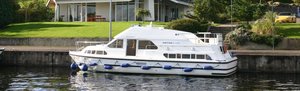 Hausboot am Ufer des River Shannon in Irland, umgeben von grüner Landschaft und moderner Architektur. Ideal für entspannte Angelurlaube auf dem Wasser mit erstklassiger Aussicht und komfortabler Ausstattung. Perfekt für Abenteuerlustige und Naturliebhaber.