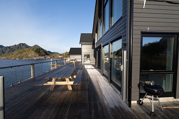 Moderne Unterkunft in Nordland, Norwegen, direkt am Wasser. Große Terrasse mit Picknicktisch und Grill. Ideal für Angelreisen und entspannte Urlaubstage mit beeindruckender Aussicht auf Fjorde und Berge. Optimal für Outdoor-Enthusiasten und Naturgenießer.