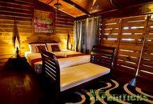 Gemütliches Schlafzimmer in einer Holzhütte in Tansania, luxuriös ausgestattet mit Doppelbett, warmen Holzwänden und stilvollen Accessoires für entspannten Angelurlaub. Ideal zum Erholen nach einem erfolgreichen Angelausflug. Perfekte Kombination aus Komfort und Naturverbundenheit.