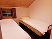 Gemütliches Schlafzimmer in Nord-Norwegen mit zwei Einzelbetten und Holzdecke. Ideal für Angler und Abenteurer, die Ruhe und Komfort in natürlicher Umgebung suchen. Perfekte Unterkunft für deinen nächsten Angelurlaub.
