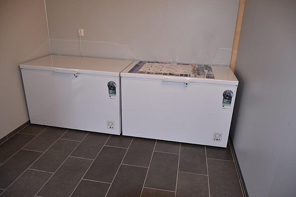 Zwei große Gefriertruhen auf grauen Fliesen in einem Raum in Südwest-Norwegen. Ideal zum Lagern von frischem Fischfang bei Angelurlauben. Perfekt für passionierte Angler, um den Fang optimal zu konservieren.