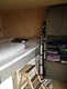 Gemütliches Holzzimmer in Nordland, Norwegen: Hochbett mit Leiter, gut ausgestatteter Schrank mit Kleidung und praktischer Holztrittleiter. Ideal für Angelurlauber, die Komfort und Funktionalität schätzen.