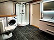 Ein modernes Badezimmer in Hitra, Norwegen, mit Dusche, Waschmaschine und Trockner. Perfekt für Angler, die nach einem erfolgreichen Tag im Angelurlaub Komfort und Bequemlichkeit suchen. Sorglos angeln und entspannen.
