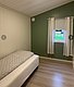 Gemütliches Schlafzimmer in Hitra, Norwegen: Einzelbett, grüne Wand, kleine Fensteransicht mit Vorhängen. Ruhig und einladend, ideal für Angelurlauber. Entspanne hier nach einem aufregenden Tag voller Abenteuer und Fänge.