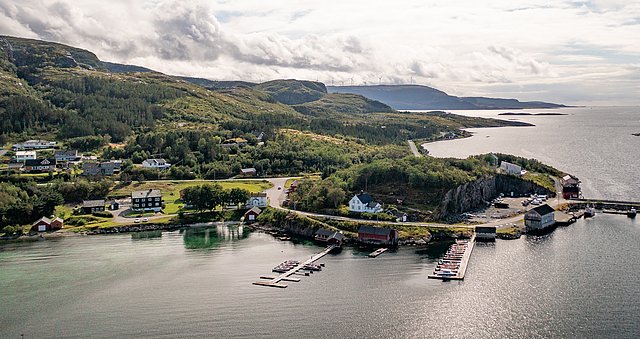 Luftbild von Hitra, Norwegen: malerische Küstenlinie mit grünen Hügeln, kleinen Dörfern und Hafen. Perfekter Ort für Angelabenteuer und Naturerlebnisse. Ideal für Angelurlaub und Meeresangeln.