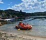Klares Wasser, idyllische Landschaft bei Hitra, Norwegen: Zwei Kinder in einem Schlauchboot genießen entspannte Momente am Ufer. Perfekter Angelurlaub für die ganze Familie in unberührter Natur.