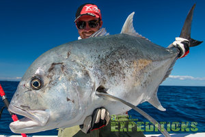 Ein Angler präsentiert stolz einen großen Fisch vor der Küste von Mitsio Island, Madagaskar. Perfektes Ziel für begeisterte Meeresangler, die auf der Suche nach aufregenden Angelabenteuern in exotischer Umgebung sind. Klarer Himmel und strahlend blaues Meer.