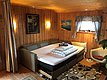 Gemütliche Holzhütte auf Hitra, Norwegen: Wohnzimmer mit ausziehbarem Sofa, Wandbildern und Fensterblick. Ideal für Angelreisen und erholsamen Angelurlaub. Willkommen in der entspannten Atmosphäre dieser charmanten Unterkunft.