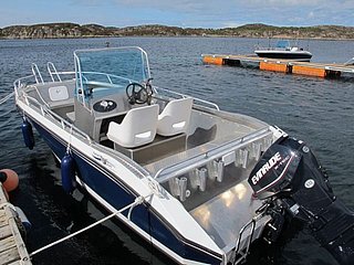 Ein modernes Angelboot mit Außenbordmotor liegt an einem ruhigen Seeufer in Tanzania. Perfekt für ausgedehnte Angelabenteuer und unvergessliche Bootsfahrten in malerischer Naturkulisse.