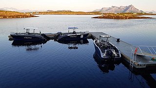 Norwegische Angelidylle: Drei Boote am Steg in Hitra, umgeben von ruhigem Wasser und malerischer Bergkulisse. Perfekter Ausgangspunkt für einen erfolgreichen Angelurlaub in der zauberhaften Natur Norwegens.