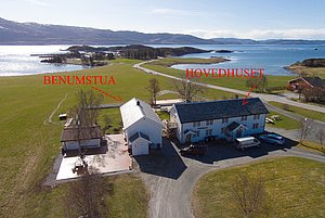 Luftaufnahme von Unterkünften in Hitra, Norwegen, umgeben von grünen Wiesen und malerischem Meerblick. Perfekt für einen entspannenden Angelurlaub inmitten nordischer Natur. Ideal für Angler, die Abenteuer und Ruhe kombinieren wollen.