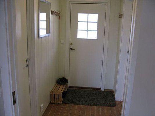 Moderner Eingangsbereich in Nordland, Norwegen, mit heller Holzeinrichtung, Eingangsdeko und praktischer Schuhablage auf Fliesenboden – perfekt als Ausgangspunkt für Angelabenteuer.