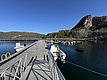 Der Pier in Hitra, Norwegen, bietet klare, ruhige Gewässer und eine beeindruckende Bergkulisse. Perfekter Ausgangspunkt für Angelabenteuer auf dem malerischen Fjord. Ideal für entspannte Tage in der Natur.