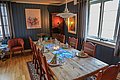 Einladendes, rustikales Esszimmer in Nord-Norwegen mit Holztisch, gemütlicher Beleuchtung und dekorativem Gedeck. Warme Farben und Kunst an den Wänden schaffen eine heimelige Atmosphäre. Perfekt für entspannte Abende nach einem erfolgreichen Angelurlaub.