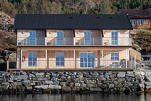 Moderne Holzhütte direkt am Wasser in Hitra, Norwegen. Gemütliche Unterkunft für Angelreisende, umgeben von malerischer Natur. Ideal für entspannte Angelurlaube und Abenteuer in der Region. Perfekter Rückzugsort für Enthusiasten.