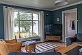 Gemütliches Wohnzimmer in Hitra, Norwegen, mit Blick auf die Natur. Große Fenster, komfortable Sitzecke, Fernseher und dekorative Accessoires schaffen ein behagliches Ambiente – perfekt für entspannende Angelurlaube.