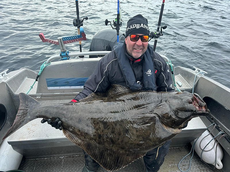 Ein Angler hält stolz einen großen Fisch auf einem Boot. Perfekter Angelurlaub am River Shannon, Irland – fischreiche Gewässer und spannende Abenteuer für Petrijünger. Ideal für Angelfans, die unvergessliche Erlebnisse suchen.