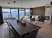 Moderne skandinavische Ferienwohnung mit Panoramafenstern, die einen atemberaubenden Blick auf die Küstenlandschaft Südwest-Norwegens bieten. Stilvolles Interieur mit Holztönen und Kamin laden zur Entspannung nach einem Angelabenteuer ein. Ideal für Angelreisen.