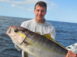 Ein Angler hält stolz einen großen Fisch auf dem offenen Meer vor der Küste von São Vicente, Kapverden. Ideal für Abenteuer-Angelreisen und Meeresangler auf der Suche nach unvergesslichen Fangmomenten.