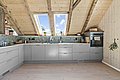 Gemütliche Dachküche in Südwest-Norwegen mit Holzakzenten, Dachfenstern und moderner Ausstattung. Helle Holzdecke und stilvolle, graue Küchenschränke schaffen eine einladende Atmosphäre. Ideal für entspanntes Kochen nach einem erfolgreichen Angeltag.