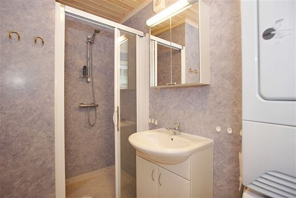 Modernes Badezimmer in Nordland, Norwegen mit begehbarer Dusche, Waschbecken und blauen Wänden. Ideal für Erholung nach einem erlebnisreichen Angelurlaub. Optimaler Komfort und Funktionalität in skandinavischem Design. Perfekt für Angler und Naturliebhaber.