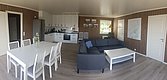Helles, modernes Wohnzimmer in Nordland, Norwegen: Offene Küche, Esstisch, gemütliche Couch, Holzverkleidung. Ideal für Angelreisen und entspannte Abende nach erfolgreichen Angeltouren. Perfektes Ferienhaus für Naturliebhaber und Abenteuerlustige.