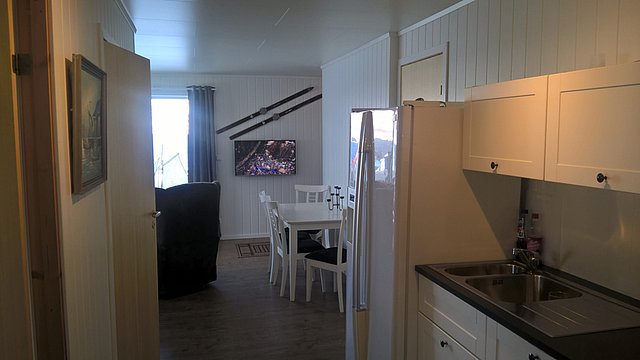 Gemütliches Ferienhaus in Nord-Norwegen mit moderner Küche, Esstisch und gemütlicher Sitzecke. Ideal für Angelreisen, um die natürliche Schönheit der Region zu genießen. Perfekt ausgestattet für erholsame Urlaubstage.