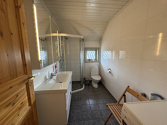 Das Bild zeigt ein helles, modern eingerichtetes Badezimmer in Hitra, Norwegen, mit Dusche, WC und Waschbecken. Ideal für Angelurlauber, die Komfort und Sauberkeit schätzen. Perfekte Erholung nach erfolgreichen Angelausflügen.