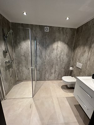 Modernes Badezimmer in Nordland, Norwegen: helle Fliesen, stilvolle Dusche, WC und Waschtisch. Ideal für entspannten Angelurlaub. Barrierefreie Ausstattung mit moderner Beleuchtung für maximalen Komfort nach einem erfolgreichen Tag am Meer.