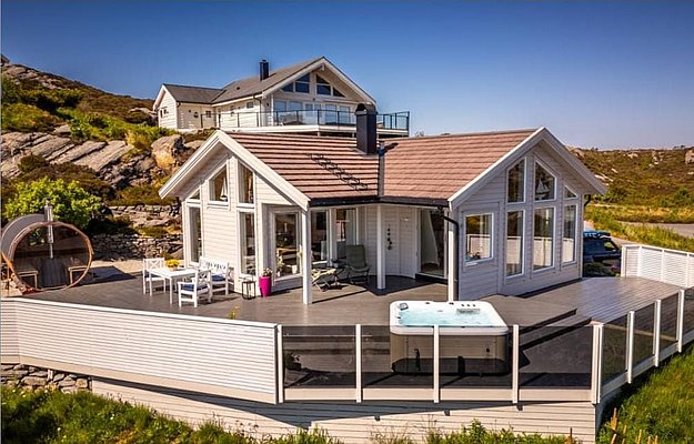 Modernes Ferienhaus in Südwest-Norwegen mit großer Terrasse, Whirlpool und Panoramafenstern. Umgeben von malerischer Natur und felsigen Hügeln – ideal für Angelurlaube und Erholung in skandinavischer Idylle. Perfekt für Abenteuer und Entspannung zugleich.