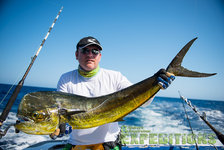 Ein Angler hält einen großen Mahi-Mahi auf einem Boot im kristallklaren Wasser der Malediven, ideal für Meeresangeln. Perfekter Angelurlaub für Abenteuerlustige.