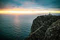 Beeindruckender Ausblick am Nordkap in Nord-Norwegen: Steile Klippen treffen auf die unendlichen Weiten des Ozeans, während ein leuchtender Sonnenuntergang den Himmel färbt. Perfektes Ziel für Abenteuer und Naturerlebnisse.