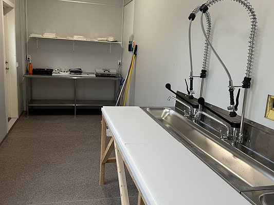 Moderne, saubere Angelhütte in Nord-Norwegen: Gut ausgestattete Küche mit Waschbecken, Arbeitsflächen und Ablage für einen komfortablen Angelurlaub. Perfekt für die Fischverarbeitung nach einem erfolgreichen Angelausflug.