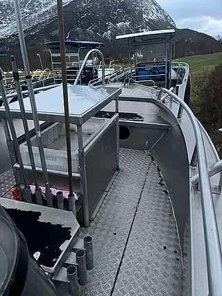 Gruppe von Angelbooten in Südwest-Norwegen, umgeben von schneebedeckten Bergen. Ideales Ziel für Angelreisen mit beeindruckender Landschaft. Die robuste Ausstattung der Boote verspricht unvergessliche Erlebnisse beim Meeresangeln.